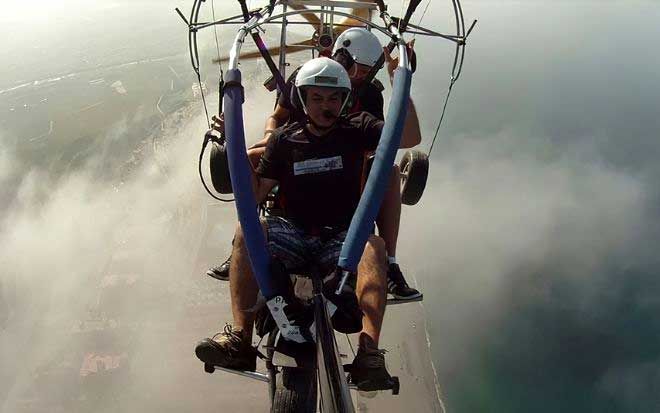 foto de vuelo con parapente a motor encima de nubes en la costa de granada con parapente tropical